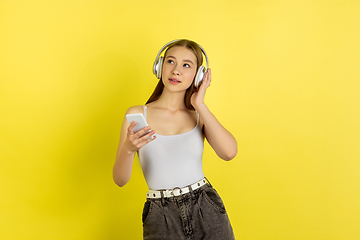 Image showing Caucasian young girl\'s portrait isolated on yellow studio background. Beautiful female model. Concept of human emotions, facial expression, sales, ad, youth culture.