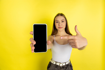 Image showing Caucasian young girl\'s portrait isolated on yellow studio background. Beautiful female model. Concept of human emotions, facial expression, sales, ad, youth culture.