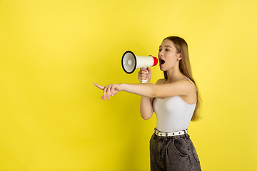 Image showing Caucasian young girl\'s portrait isolated on yellow studio background. Beautiful female model. Concept of human emotions, facial expression, sales, ad, youth culture.