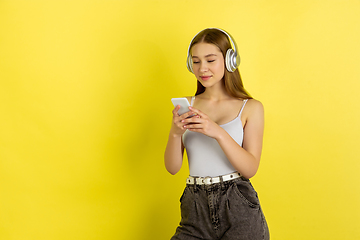 Image showing Caucasian young girl\'s portrait isolated on yellow studio background. Beautiful female model. Concept of human emotions, facial expression, sales, ad, youth culture.