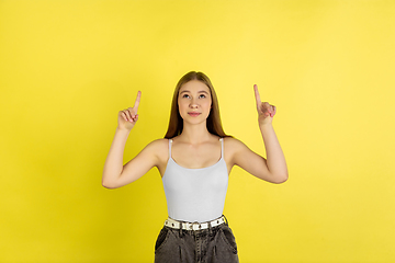 Image showing Caucasian young girl\'s portrait isolated on yellow studio background. Beautiful female model. Concept of human emotions, facial expression, sales, ad, youth culture.