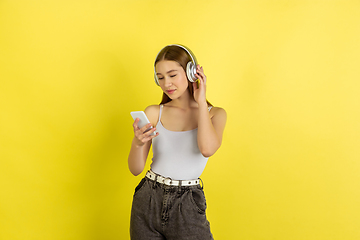 Image showing Caucasian young girl\'s portrait isolated on yellow studio background. Beautiful female model. Concept of human emotions, facial expression, sales, ad, youth culture.