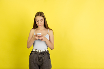 Image showing Caucasian young girl\'s portrait isolated on yellow studio background. Beautiful female model. Concept of human emotions, facial expression, sales, ad, youth culture.