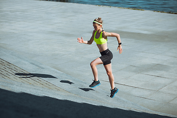 Image showing Female runner, athlete training outdoors in summer\'s sunny day.