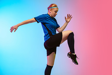 Image showing Female soccer, football player training in action isolated on gradient studio background in neon light