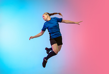 Image showing Female soccer, football player training in action isolated on gradient studio background in neon light