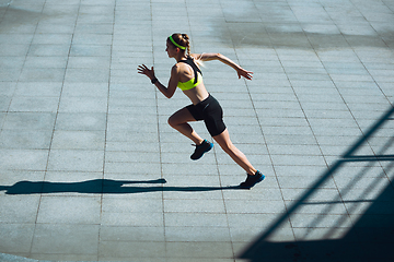 Image showing Female runner, athlete training outdoors in summer\'s sunny day.