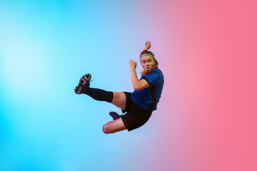 Image showing Female soccer, football player training in action isolated on gradient studio background in neon light