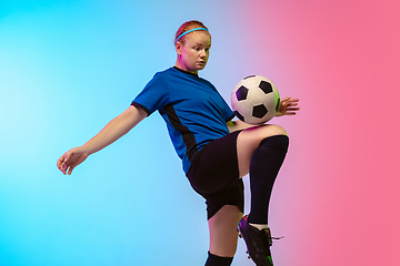 Image showing Female soccer, football player training in action isolated on gradient studio background in neon light