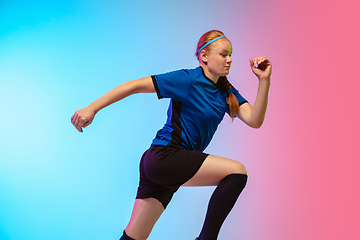 Image showing Female soccer, football player training in action isolated on gradient studio background in neon light