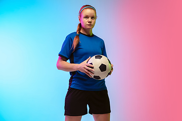 Image showing Female soccer, football player training in action isolated on gradient studio background in neon light