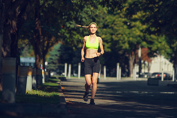 Image showing Female runner, athlete training outdoors in summer\'s sunny day.