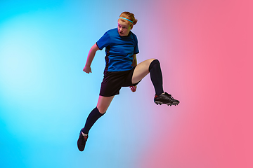 Image showing Female soccer, football player training in action isolated on gradient studio background in neon light