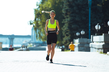 Image showing Female runner, athlete training outdoors in summer\'s sunny day.