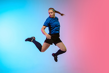 Image showing Female soccer, football player training in action isolated on gradient studio background in neon light