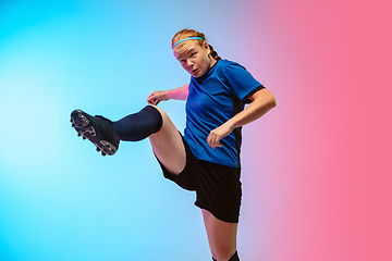 Image showing Female soccer, football player training in action isolated on gradient studio background in neon light