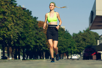 Image showing Female runner, athlete training outdoors in summer\'s sunny day.