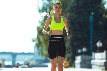 Image showing Female runner, athlete training outdoors in summer\'s sunny day.