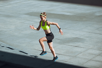 Image showing Female runner, athlete training outdoors in summer\'s sunny day.