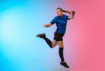 Image showing Female soccer, football player training in action isolated on gradient studio background in neon light