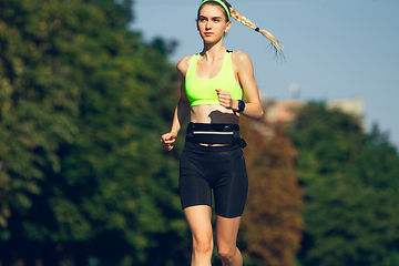 Image showing Female runner, athlete training outdoors in summer\'s sunny day.