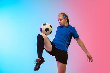 Image showing Female soccer, football player training in action isolated on gradient studio background in neon light