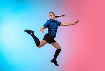 Image showing Female soccer, football player training in action isolated on gradient studio background in neon light