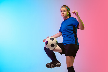 Image showing Female soccer, football player training in action isolated on gradient studio background in neon light