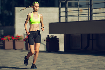 Image showing Female runner, athlete training outdoors in summer\'s sunny day.