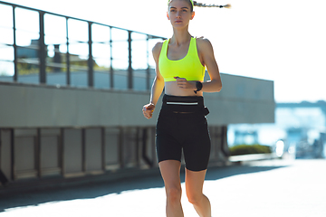 Image showing Female runner, athlete training outdoors in summer\'s sunny day.