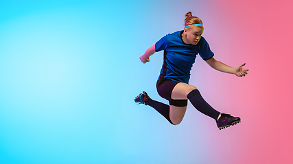 Image showing Female soccer, football player training in action isolated on gradient studio background in neon light