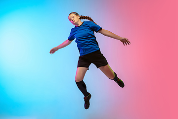 Image showing Female soccer, football player training in action isolated on gradient studio background in neon light