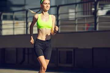 Image showing Female runner, athlete training outdoors in summer\'s sunny day.