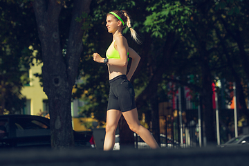 Image showing Female runner, athlete training outdoors in summer\'s sunny day.