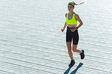 Image showing Female runner, athlete training outdoors in summer\'s sunny day.