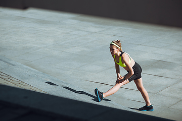 Image showing Female runner, athlete training outdoors in summer\'s sunny day.