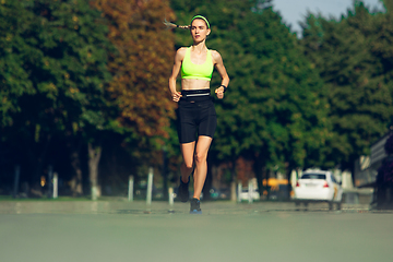 Image showing Female runner, athlete training outdoors in summer\'s sunny day.