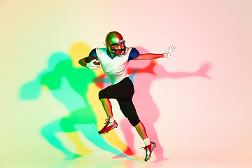 Image showing American football player isolated on gradient studio background in neon light with shadows