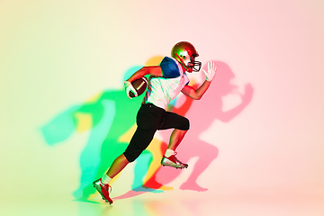 Image showing American football player isolated on gradient studio background in neon light with shadows