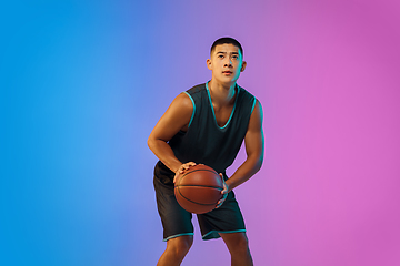 Image showing Young basketball player in motion on gradient studio background in neon light