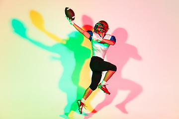 Image showing American football player isolated on gradient studio background in neon light with shadows