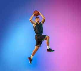 Image showing Young basketball player in motion on gradient studio background in neon light