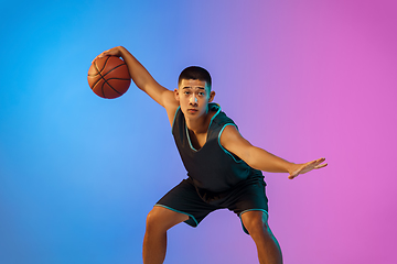 Image showing Young basketball player in motion on gradient studio background in neon light