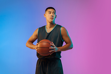 Image showing Young basketball player in motion on gradient studio background in neon light