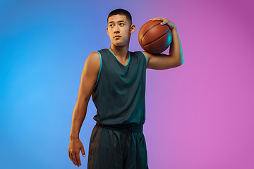 Image showing Young basketball player in motion on gradient studio background in neon light