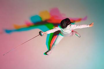 Image showing Teen girl in fencing costume with sword in hand on gradient background with neon light, top view