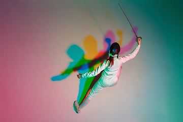 Image showing Teen girl in fencing costume with sword in hand on gradient background with neon light, top view