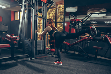 Image showing Young muscular caucasian woman practicing in gym with equipment. Wellness, healthy lifestyle, bodybuilding.