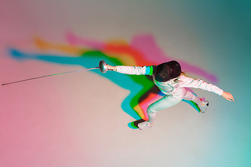 Image showing Teen girl in fencing costume with sword in hand on gradient background with neon light, top view