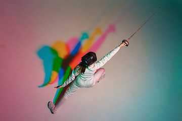 Image showing Teen girl in fencing costume with sword in hand on gradient background with neon light, top view